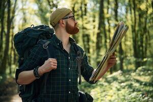 Using the map. Bearded man is in ,,the forest at daytime photo