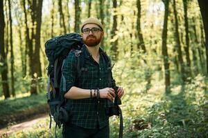 Tourist with binoculars., Bearded man is in the forest at daytime photo