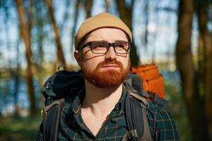 Front view. Bearded man is in the forest, at daytime photo