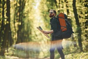 Beautiful lens effect. Bearded man, is in the forest at daytime photo