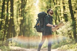 Beautiful lens, effect. Bearded, man is in the forest at daytime photo