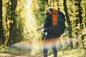 Beautiful lens effect. Bearded,, man is in the forest at daytime photo