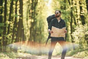 Beautiful lens,, effect. Bearded man is in the forest at daytime photo