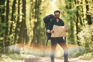 Beautiful, lens effect. Bearded man is in the forest at daytime photo