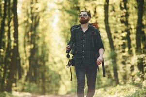 Fron,t view. Bearded man is in the forest at daytime photo