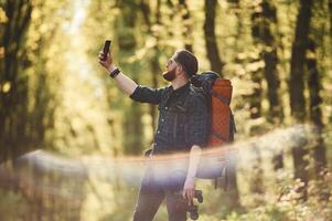 Colorful,, lens effect. Bearded man is in the forest at daytime photo