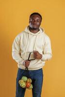 Many of the fruits in the bag... Black guy is against yellow background photo