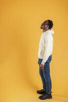 In glasses, looks to the ,copy, space. Black guy is against yellow background photo