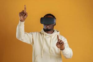 Playing VR game.. In, virtual reality, glasses. Black guy is against yellow background photo