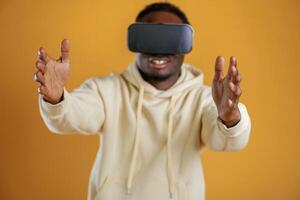 The ,future is ,now, playing virtual reality game. Black guy is against yellow background photo
