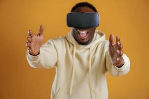The future is now,, playing virtual, reality game. Black guy is against yellow background photo