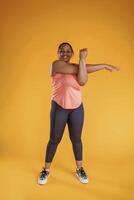 Warm, up exercises for hands. African American woman is in the studio against yellow background photo