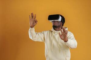 Playing VR game. In ,virtual reality glasses. Black guy is against yellow background photo