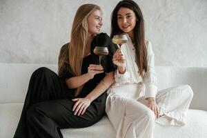 Event, with drinks, celebrating. Two happy young female best, friends ,are indoors photo