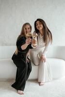 Event, with drinks, celebrating. Two happy ,young female best friends are indoors photo