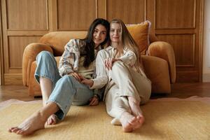 Front view,, sitting. Two happy young female best friends are indoors photo