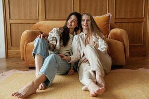 Front, view, sitting. Two happy young female best friends are indoors photo