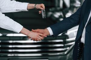 Close, up, view of, woman giving keys of new car to the businessman photo
