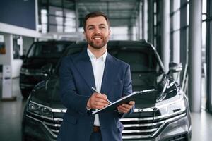 Cheerful ,salesman... Guy is in a car dealership photo
