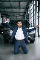 Happy new owner of automobile... A, businessman is in a car dealership photo