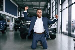 Happy new owner of ,automobile. A businessman is in a car dealership photo