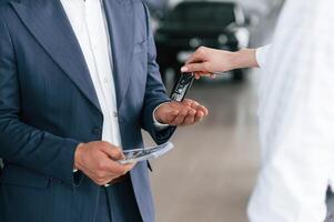 Close up, view of woman giving keys of new car to the businessman photo