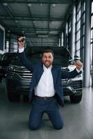 Happy, new owner of automobile. A businessman is in a car dealership photo