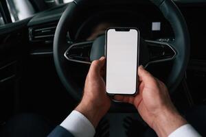 White, copy space on smartphone. Businessman is in the brand new car photo