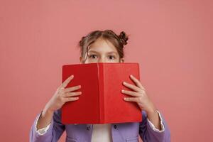 Notepad, or book, conception ,of education. Cute little girl is against pink background photo