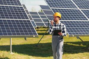 Communication by using walkie talkie... Engineer with photovoltaic solar panels outdoors at daytime photo
