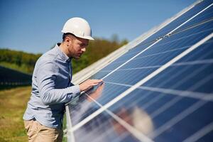 Checking the surface.. Engineer with photovoltaic solar panels outdoors at daytime photo