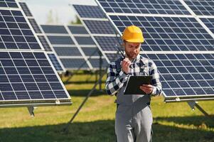 Communication ,by using walkie, talkie. Engineer with photovoltaic solar panels outdoors at daytime photo