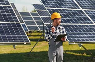 Communication by using,, walkie talkie. Engineer with photovoltaic solar panels outdoors at daytime photo