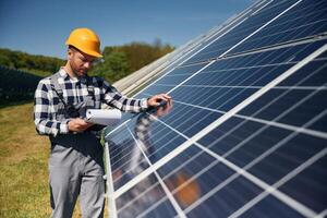 Checking ,the surface. Engineer ,with photovoltaic solar panels outdoors at daytime photo
