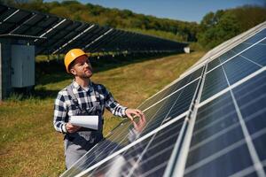Checking the ,,surface. Engineer, with photovoltaic solar panels outdoors at daytime photo