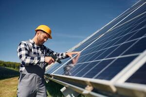 Almost ,,done, installation by using drill. Engineer with photovoltaic solar panels outdoors at daytime photo