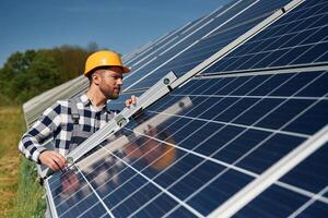 Using the leveler,, tool. Engineer with photovoltaic solar panels outdoors at daytime photo