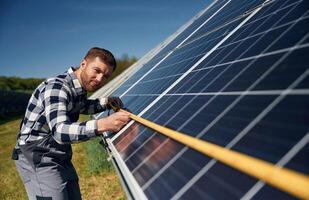 Measuring the width by tape.. Engineer with photovoltaic solar panels outdoors at,, daytime photo