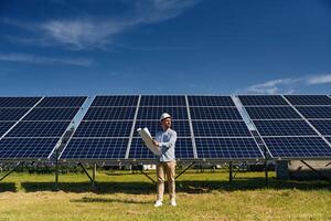 Distant view. Engineer with photovoltaic ,,solar panels outdoors at daytime photo