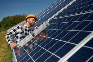 Using ,,the leveler tool. Engineer with photovoltaic solar panels outdoors at daytime photo