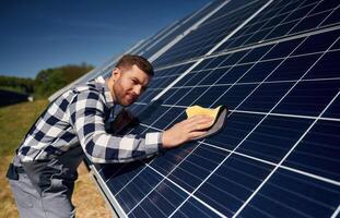 Surface must, me clean. Engineer with photovoltaic solar panels outdoors at daytime photo
