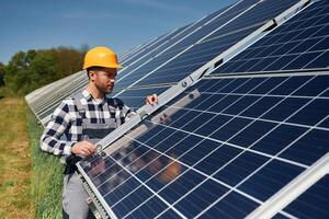 Using the leveler tool.. Engineer with photovoltaic solar panels outdoors at daytime photo