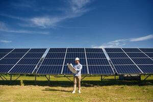 Distant view.. Engineer with photovoltaic solar panels outdoors at daytime photo