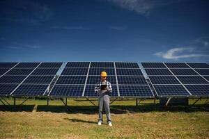 Black ,notepad in, hands. Engineer with photovoltaic solar panels outdoors at daytime photo