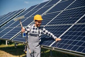 Procedure of cleaning ,,the surface. Engineer with photovoltaic solar panels outdoors at daytime photo
