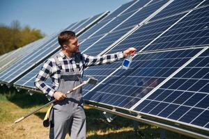 Procedure, of, cleaning the surface. Engineer with photovoltaic solar panels outdoors at daytime photo