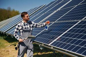 Procedure of ,cleaning the surface. Engineer with photovoltaic solar panels outdoors at daytime photo