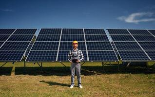 Distant, view.. Engineer with photovoltaic solar panels outdoors at daytime photo