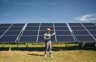 Distant, view. ..Engineer with photovoltaic solar panels outdoors at daytime photo