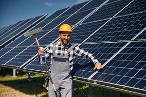 Procedure ,of cleaning the surface. Engineer with photovoltaic solar panels outdoors at daytime photo